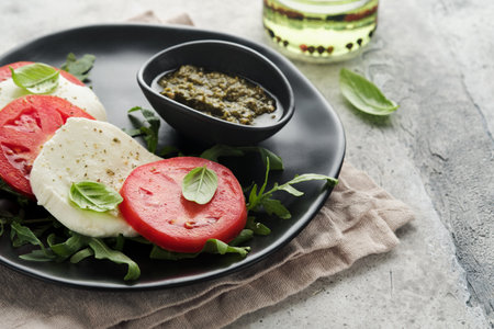 Caprese salad. Italian caprese salad with sliced tomatoes, mozzarella cheese, arugula, basil, olive...