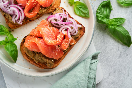 Sandwiches with salted salmon, avocado guacamole, red onions and basil. Smorrebrod. Set of Danish open sandwiches. Healthy food, breakfast. Clean eating, dieting, vegan food concept. top view.の写真素材