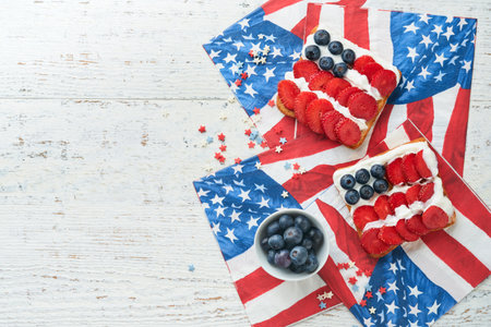 4th of July American Independence Day food. American flag sandwich with strawberries, blueberries, whipped sweet cream, soft cheese on toast bread. Independence or Patriotic Day breakfast idea Mock upの写真素材