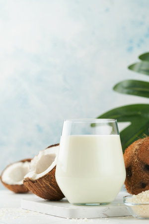 Glass of coconut milk and coconut close up on a white background with space for text. Coconut vegan milk non dairy or Dairy free milk concept. Healthy vegan food.の写真素材