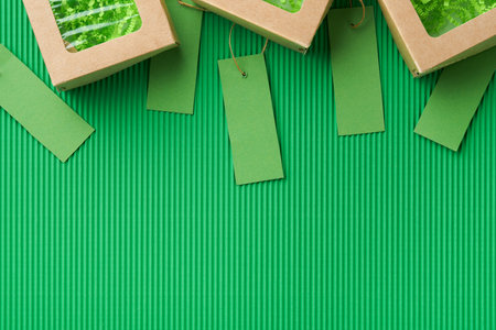 Green Friday background mock up. Sale Tag on green background. Paper shopping boxes and green tag. Environmentally friendly shopping idea, useful things on sale. Reducing excessive consumption.の写真素材