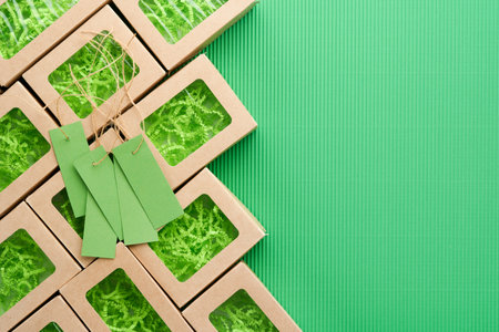 Green Friday background mock up. Sale Tag on green background. Paper shopping boxes and green tag. Environmentally friendly shopping idea, useful things on sale. Reducing excessive consumption.の写真素材