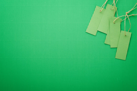 Green Friday background mock up. Sale Tag on green background. Paper shopping boxes and green tag. Environmentally friendly shopping idea, useful things on sale. Reducing excessive consumption.の写真素材