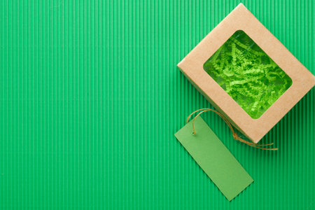Green Friday background mock up. Sale Tag on green background. Paper shopping boxes and green tag. Environmentally friendly shopping idea, useful things on sale. Reducing excessive consumption.の写真素材