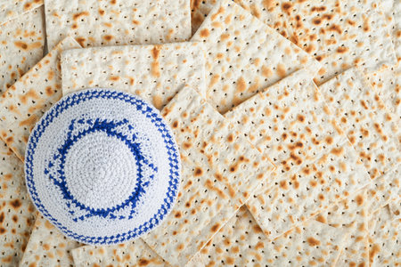 Passover celebration concept. White kippah with Star of David on Matzah texture background. Passover food. Pesach Jewish holiday. Traditional ritual Jewish bread. Passover food. top view. Mock up.の写真素材