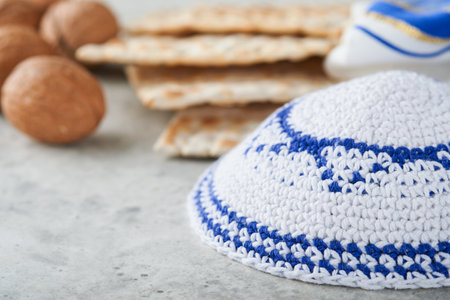 Passover celebration concept. Matzah, red kosher and walnut. Traditional ritual Jewish bread matzah, kippah and tallit on old concrete background. Passover food. Pesach Jewish holiday.の写真素材