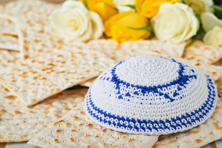 Passover celebration concept. Matzah, red kosher, white and yellow roses and walnut. Traditional...