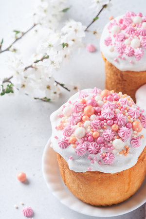 Traditional Easter sweet bread or cakes with white icing and sugar decor, colored eggs and cherry...