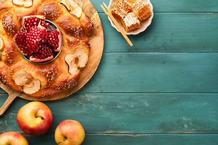 Jewish Holidays - Rosh Hashanah or Rosh Hashanah. Pomegranate, apples, honey and round challah on old wooden blue table background. Jewish autumn celebration. Shana Tova. Yom kippur concept. top viewの写真素材