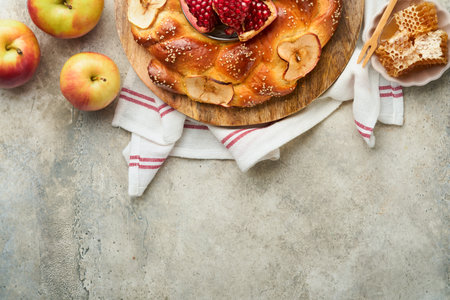 Jewish Holidays - Rosh Hashanah or Rosh Hashanah. Pomegranate, apples, honey and round challah on rustic gray table background. Jewish autumn celebration. Shana Tova. Yom kippur concept. top view.の写真素材