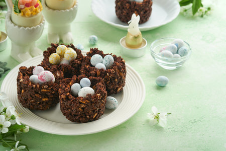 Easter chocolate nest cake with mini chocolate candy eggs with blossoming cherry or apple flowers on...