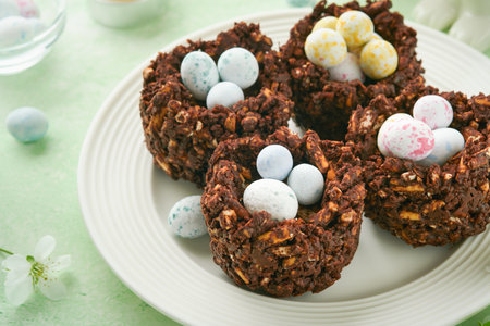 Easter chocolate nest cake with mini chocolate candy eggs with blossoming cherry or apple flowers on...