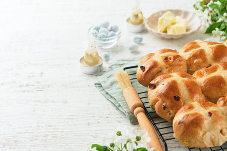 Easter brunch or breakfast. Easter chocolate nest cake with chocolate candy eggs, traditional hot cross buns and deviled eggs with bouquets of blooming apple trees. Spring Easter holiday food concept.の写真素材