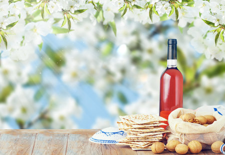 Passover celebration concept. Matzah, red kosher and walnut on wooden vintage table in front of...