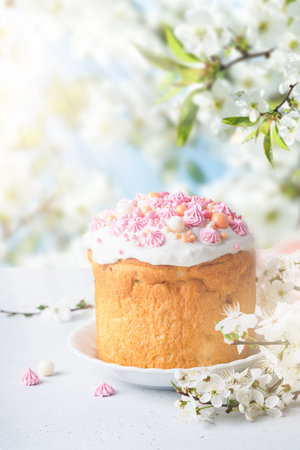 Traditional Easter cake with white swiss meringue and pink sweet decoration and colorful painted...