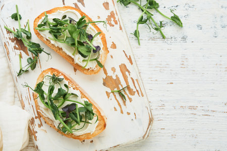 Toast or sandwich with cream cheese and micro greens peas and sunflower. Concept healthy food or snack. Flat lay, copy space.の写真素材