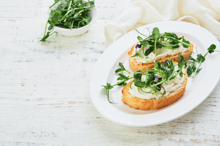 Toast or sandwich with cream cheese and micro greens peas and sunflower. Concept healthy food or snack. Flat lay, copy space.の写真素材