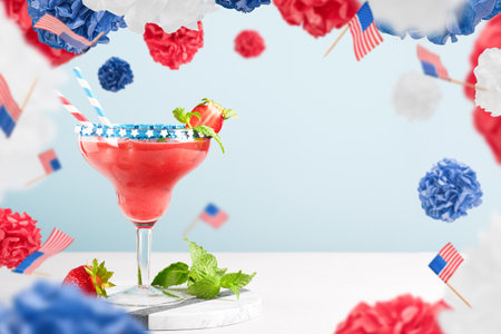 4th of July Holiday background. Patriotic Cocktail and flying or levitation USA decorative paper balls and small flags, red, blue and white colors American flag on blue background. Mock up.の写真素材