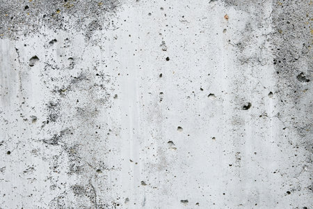 Cracked concrete wall covered with gray cement surface. Gray old wall with shabby damaged plaster or...