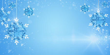 Christmas ornaments blue snowflakes hanging with sun glare and flying snow on blue background, copy space. Banner, website header, poster with cope space.の写真素材