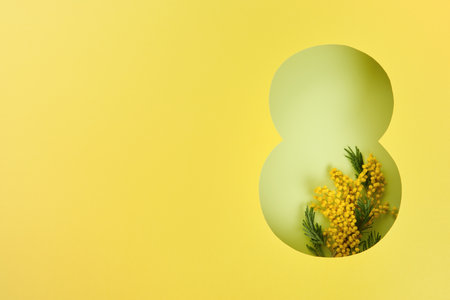 8 March greeting card. Paper cut Eight made of yellow background and fresh spring flowers bouquet of yellow mimosa. Greeting card for Womens Day on March 8 Flat lay top view. International Women's dayの写真素材