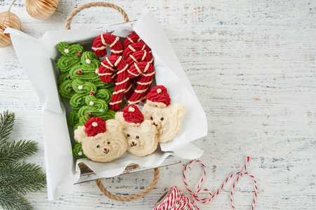 Box with variety of cookies Christmas trees, candy canes and pastry bears shortcrust pastry on light background. Traditional sweet Christmas treats for children and adults.の写真素材