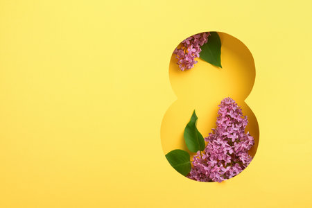 8 March greeting card. Paper cut Eight made of yellow background and fresh spring flowers bouquet of lilac. Greeting card for Womens Day on March 8 Flat lay top view. International Women's dayの写真素材