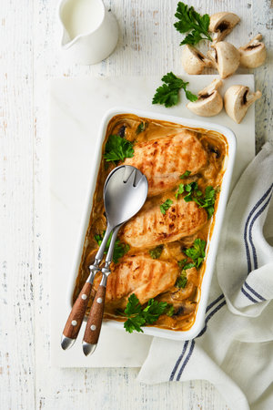Baked chicken breast bbq with mushrooms and garlic in cream sauce on white wooden table backgrounds. Top view image with ingredients for cooking. Top view with copy space.の写真素材