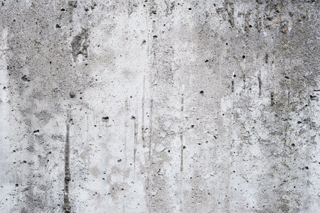 Cracked concrete wall covered with gray cement surface. Gray old wall with shabby damaged plaster or cement and brick background of an vintage dirty exfoliating plaster. Mock up.の写真素材