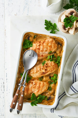 Baked chicken breast bbq with mushrooms and garlic in cream sauce on white wooden table backgrounds. Top view image with ingredients for cooking. Top view with copy space.の写真素材
