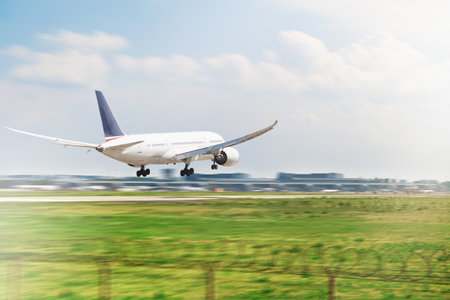 Passenger airplane landing on airport runway during on sunny day. Travel background. Business trip. Passenger airliner. Commercial aircraft.の写真素材