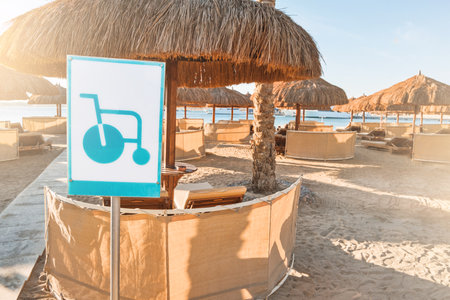 Sandy beach with disabled access at hotel resort. Beach area with sun loungers and canopy on private sandy beach with sign for disabled. Barrier free beach for people with reduced mobility.の写真素材