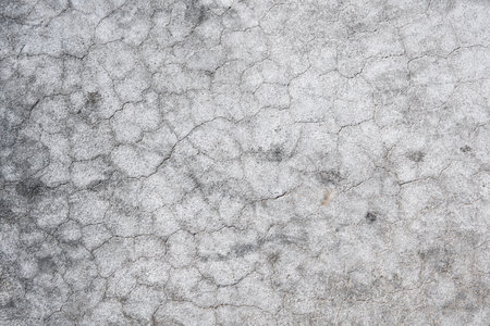 Cracked concrete wall covered with gray cement surface. Gray old wall with shabby damaged plaster or cement and brick background of an vintage dirty exfoliating plaster. Mock up.の写真素材