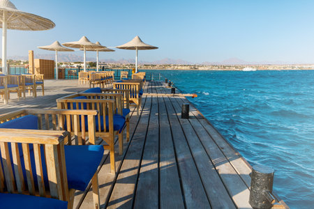 Wooden pier on sea stretching into distance beyond horizon on sunny summer day.の写真素材