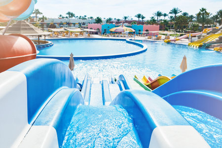 Water park with water colored flights, slides, splashes and pools at luxury hotel. summer vacation...