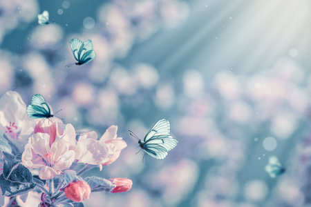 Floral spring nature abstract background with blossoming trees and fluttering butterflies on blue sky background. Dreamy gentle air artistic image. For spring cards with copy space.の写真素材