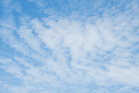 Sky. Blue sky with white clouds background. Curly clouds on a sunny summer day. Light cloudy. Good weather. Simple background sky for summer poster. Summer mock up. Soft focus.の写真素材