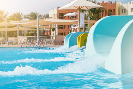 Water park with water colored flights, slides, splashes and pools at hotel. summer vacation activity...