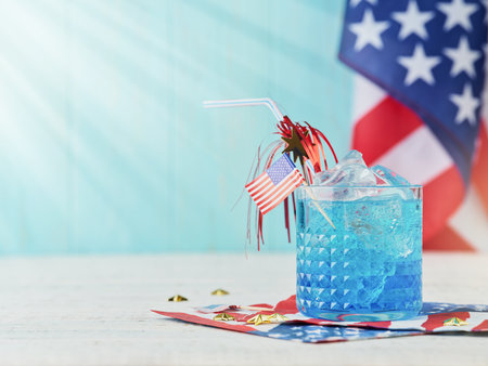 4th of July Holiday background. Cocktail with blue liqueur, American flag and festive straw against background of old turquoise board and sun rays. Patriotic American Flag drinks. Mock up.の写真素材
