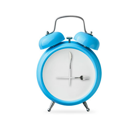 Falling blue alarm clock and white plate with fork and knife instead of hands on dial isolated on white background with clipping path. Healthy lifestyle concept. Diet or intermittent fasting conceptの写真素材