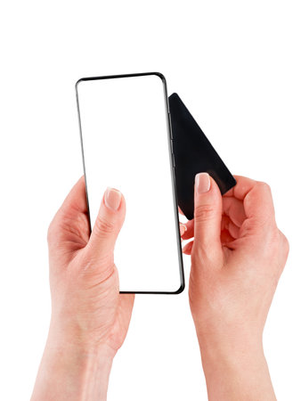Female hands holding smartphone and black credit card with empty screen isolated on white background with clipping path. Top view. Design elementの写真素材