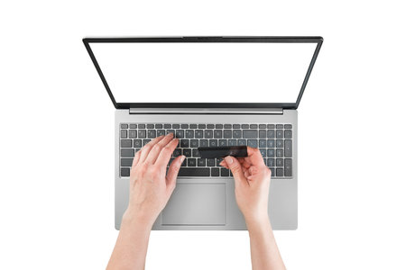 Female hands typing text or working on laptop and holds black credit cardwith empty screen isolated on white background with clipping path. Top view. Design elementの写真素材