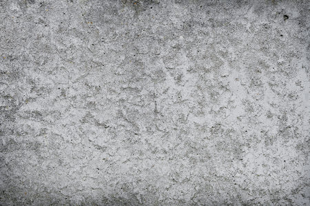 Cracked concrete wall covered with gray cement surface. Gray old wall with shabby damaged plaster or cement and brick background of an vintage dirty exfoliating plaster. Mock up.の写真素材
