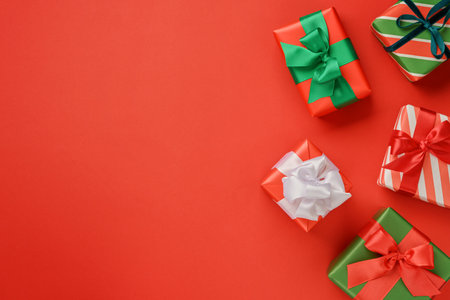 Many Christmas gift box lying on festive red background with copy space for text, Christmas card designの写真素材