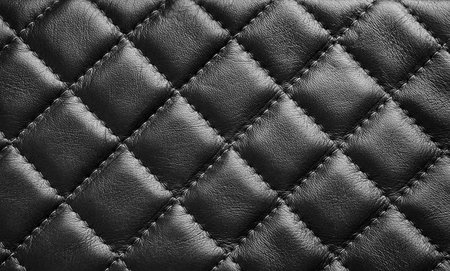 Black leather texture background with diagonal stitching. Close up seamless leather with diagonal diamond stitching. Design element.の写真素材