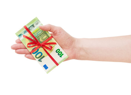 Female hand hold euro money cash stack with red ribbon and bow isolated in white background with clipping path. Design element.の写真素材