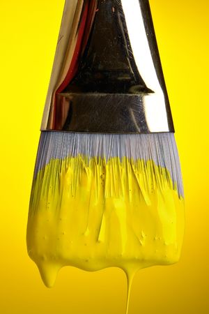 Yellow paint dripping from brushの写真素材