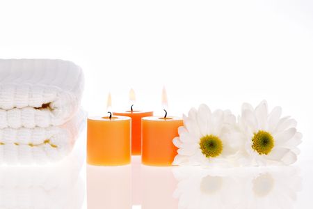 Towels, candles, and daisies on white isolatedの写真素材