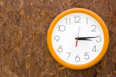 A clock hanging on a wooden wallの写真素材