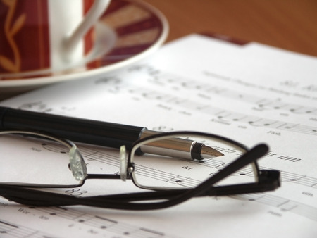 Place of employment of a music teacher. Glasses on  songbook and cup of coffee.の写真素材